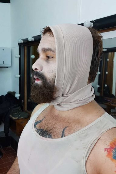 hombre con barba maquillado en blanco y con vendas